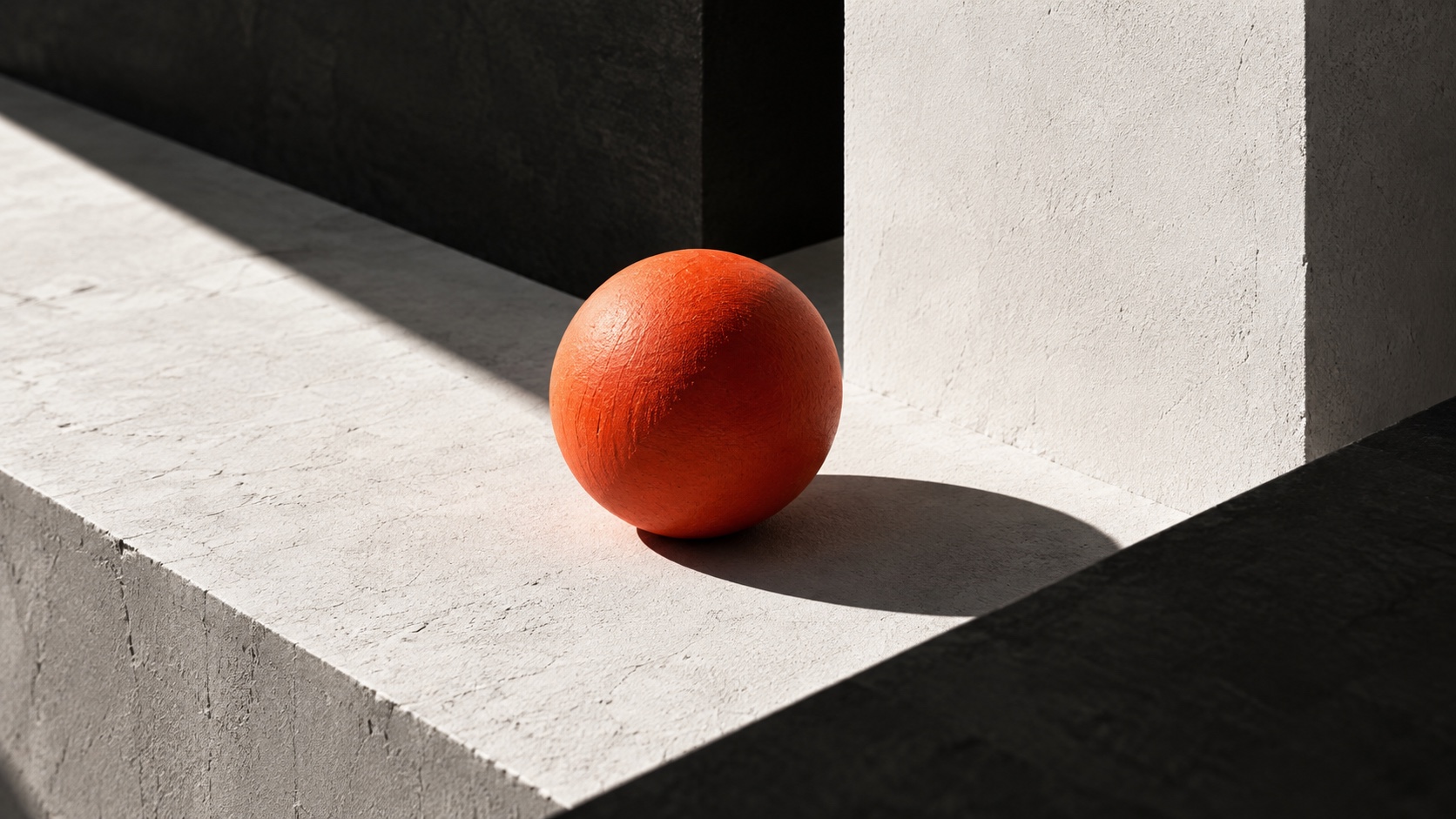 Orangefarbene Kugel, die sich von einer grauen Betonumgebung abhebt